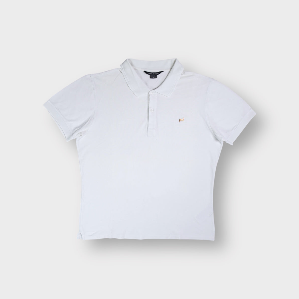 Porsche Design polo shirt in white with a metallic chest logo emblem and collar.