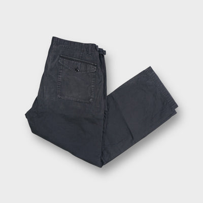 Stone Island blue pants featuring side zip pockets and a woven inner waistband tag