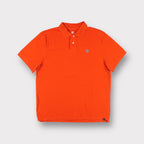 Orange Nike polo shirt featuring a blue embroidered pinwheel logo on the chest
