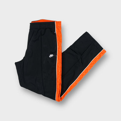 Nike trackpants in black with bright orange side stripes and embroidered logo