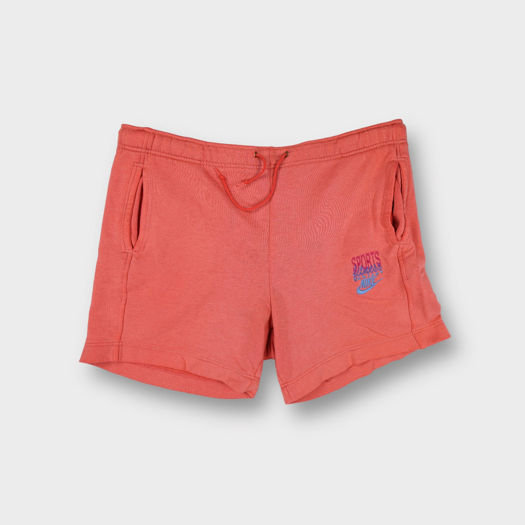 Orange Nike sweat shorts featuring a small embroidered logo on the left thigh