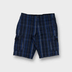 Nike shorts in blue plaid pattern featuring side cargo pockets and button closure
