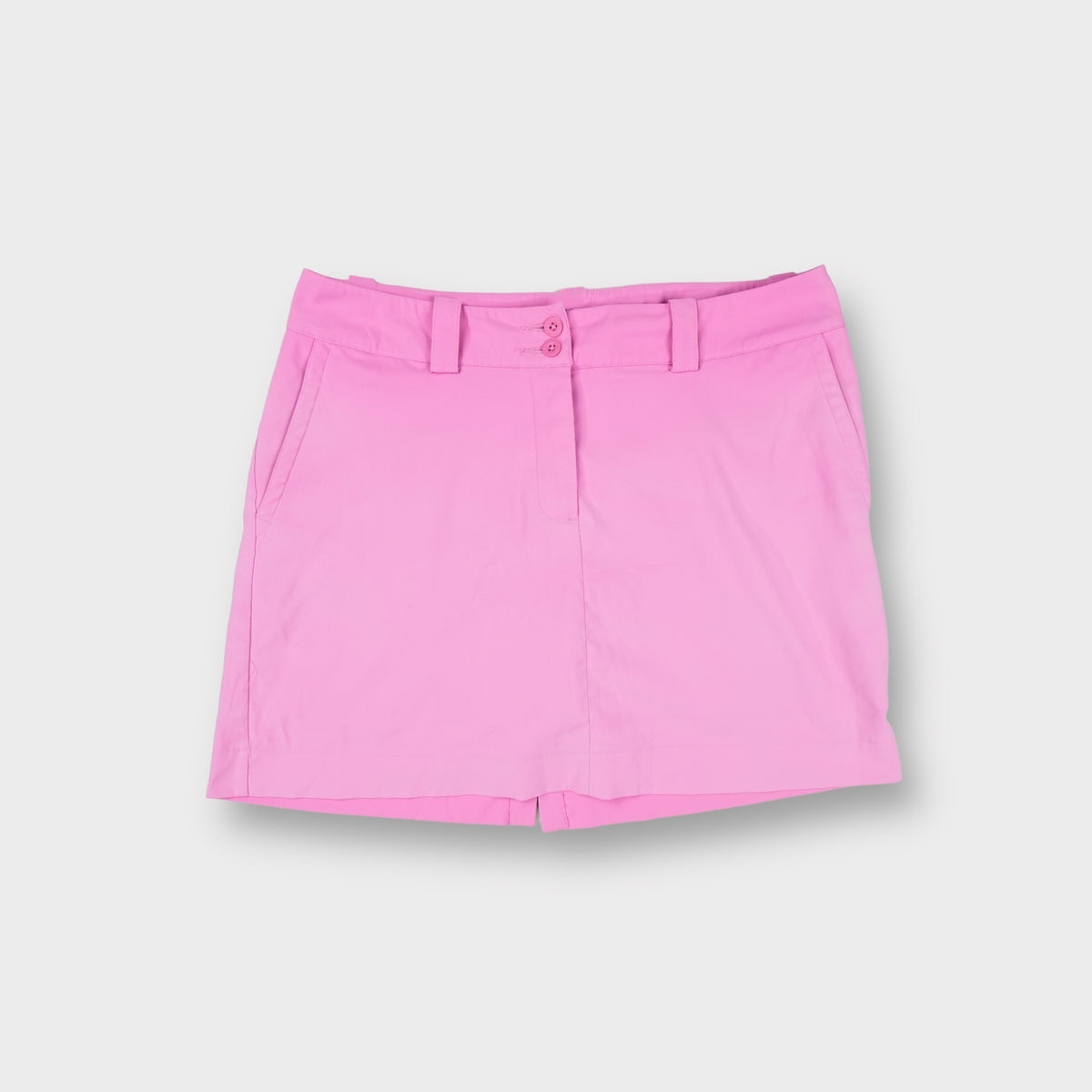 Pink Nike Golf skort with front double-button closure and small embroidered Swoosh on back