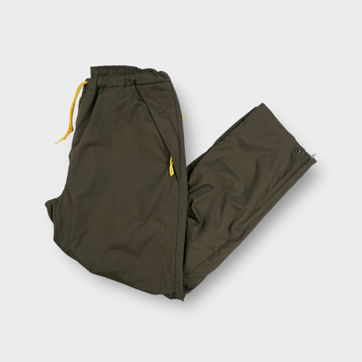 Nike khaki trackpants with yellow drawstring waistband and side zipper details