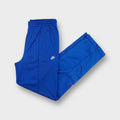 Nike trackpants in bright blue featuring an embroidered white swoosh logo on the hip