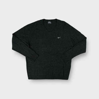 Nike Golf V-neck knit sweater in dark grey with an embroidered white swoosh on the chest.