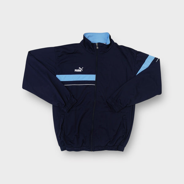 Puma black track jacket featuring a light blue chest panel and embroidered logo