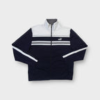 Puma full-zip track jacket in black featuring white chest panels and embroidered cat logo.