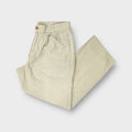 C.P. Company trousers in beige showing an embroidered patch above the back pocket.