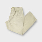 C.P. Company trousers in beige showing an embroidered patch above the back pocket.