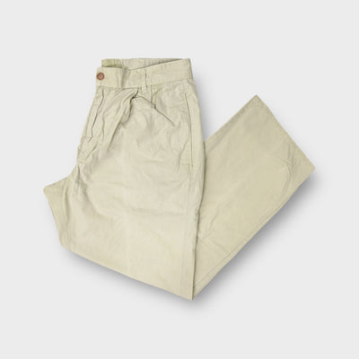 C.P. Company trousers in beige showing an embroidered patch above the back pocket.