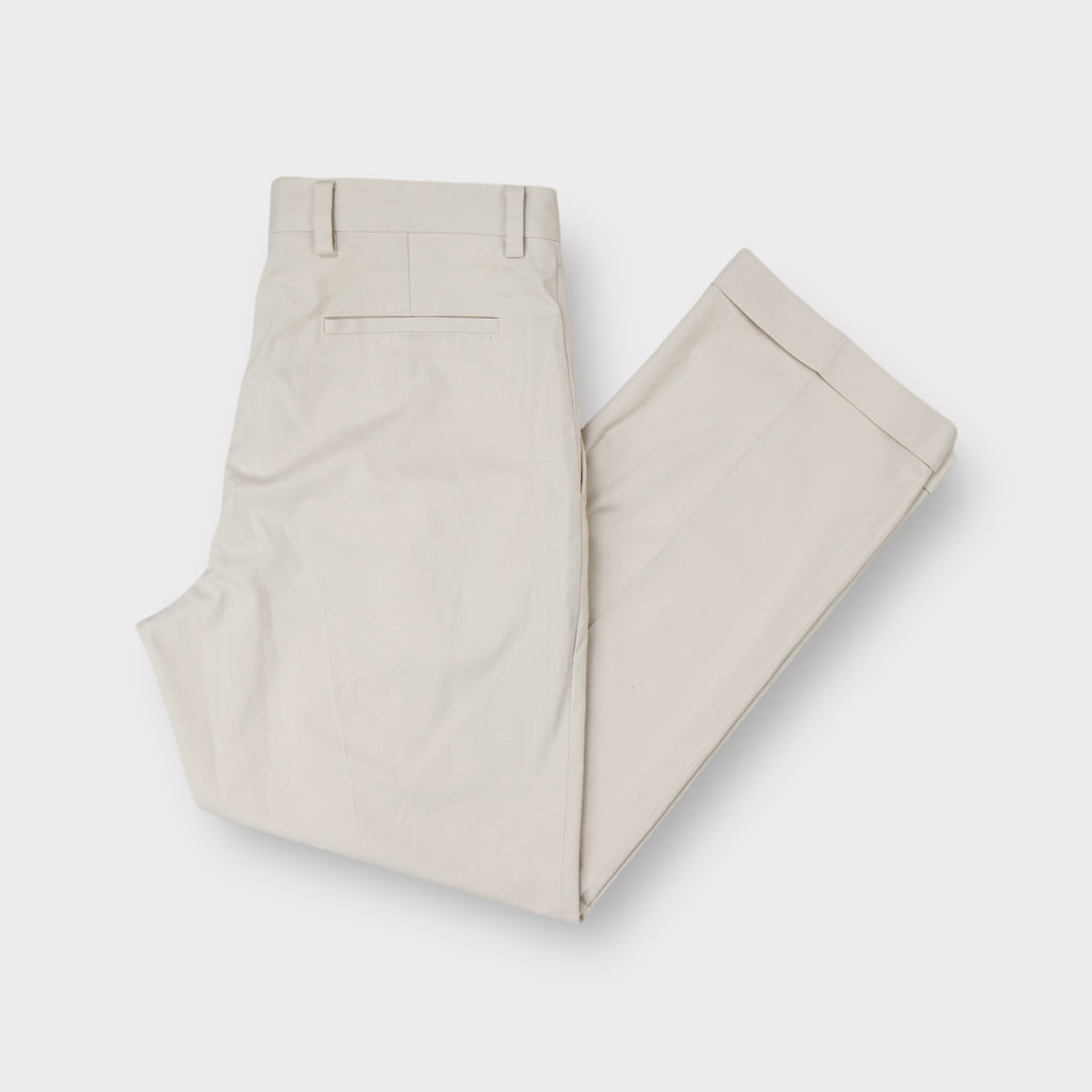 Nike beige golf trousers featuring front pleats and folded cuffed hems