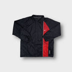 Nike jacket in black featuring a vertical red side panel and small embroidered swoosh logo