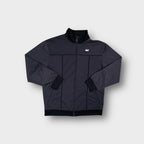 Nike full-zip track jacket in grey featuring embroidered chest logo and dark piping.