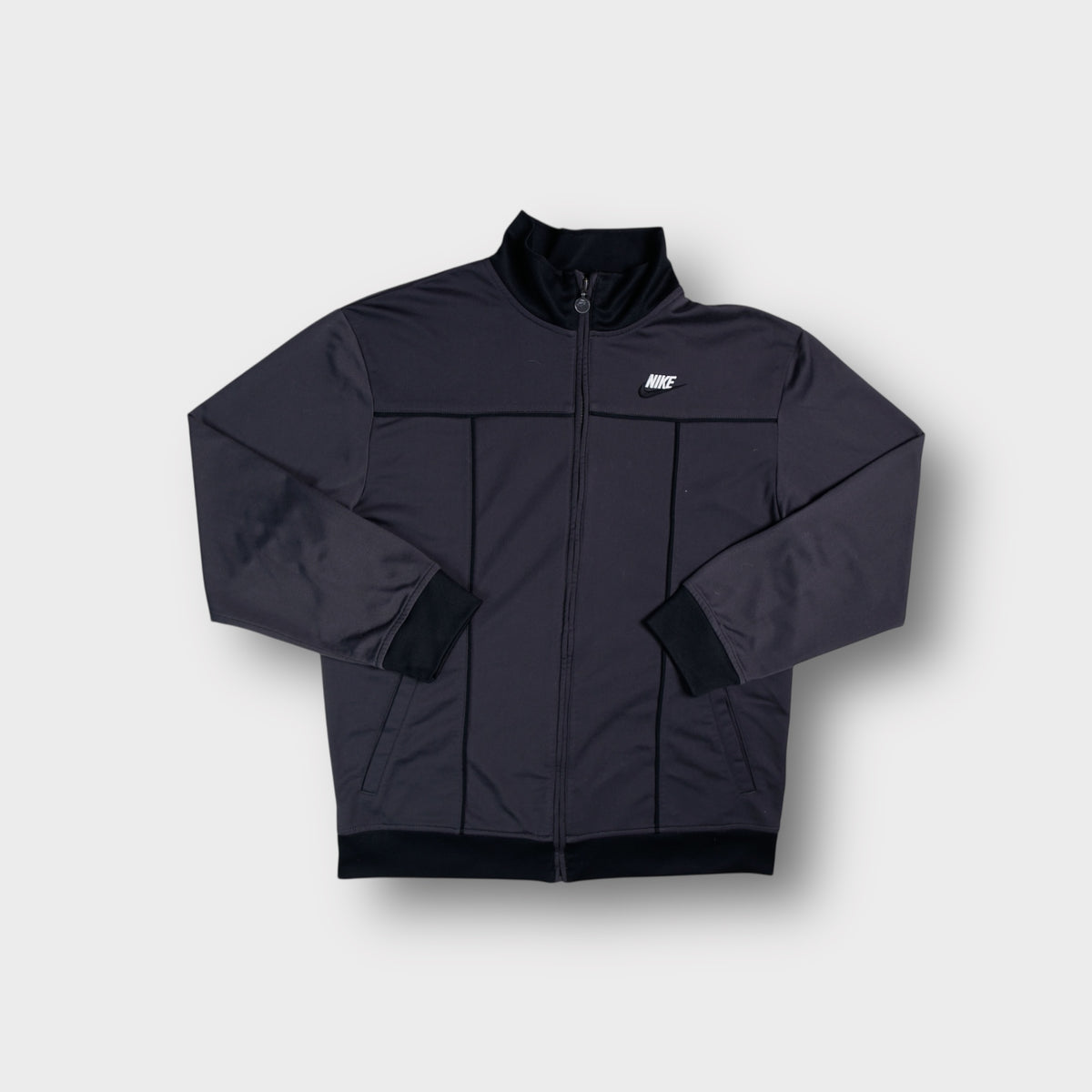 Nike full-zip track jacket in grey featuring embroidered chest logo and dark piping.