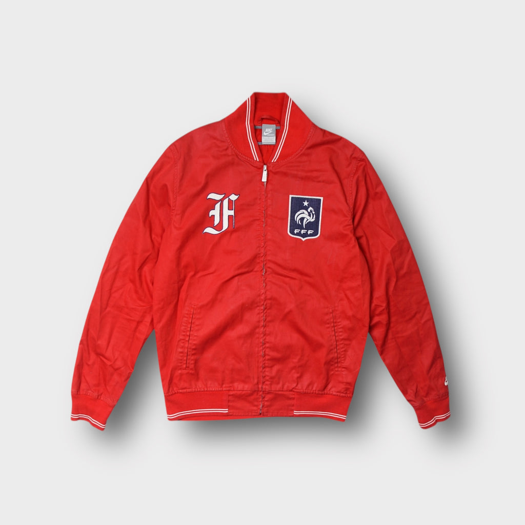 Nike full-zip jacket in red featuring a French Football Federation FFF crest patch.