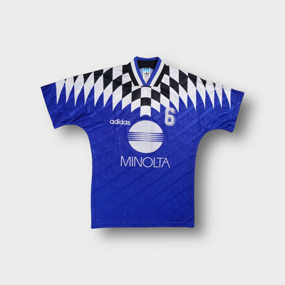 Blue Adidas football jersey featuring a white Minolta sponsor print and checked collar detail.