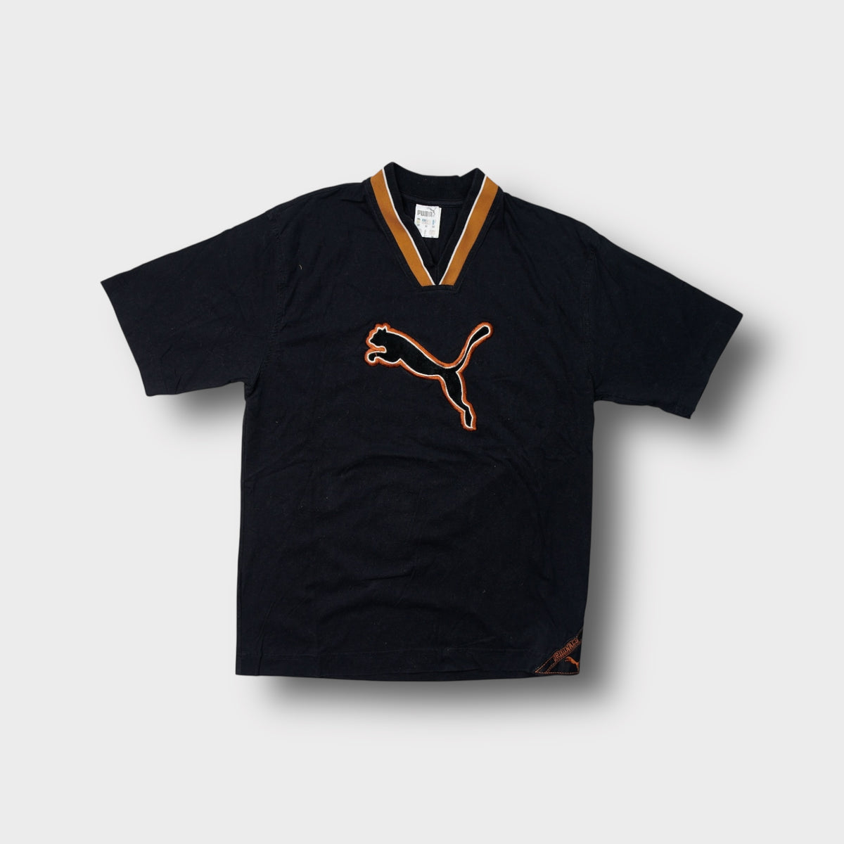 Puma T-Shirt in black with an orange ribbed V-neck collar and large chest patch logo