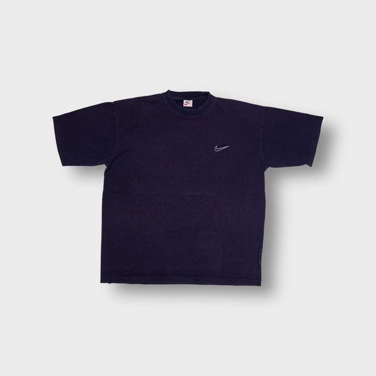 Nike short-sleeve T-Shirt in navy blue with an embroidered white Swoosh on the chest