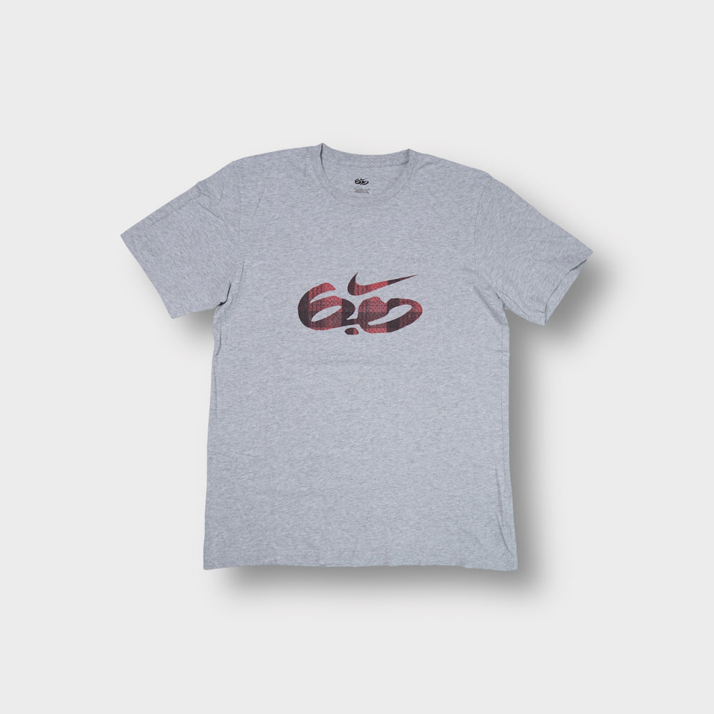 Grey Nike 6.0 T-Shirt featuring a red plaid swoosh logo printed on the chest