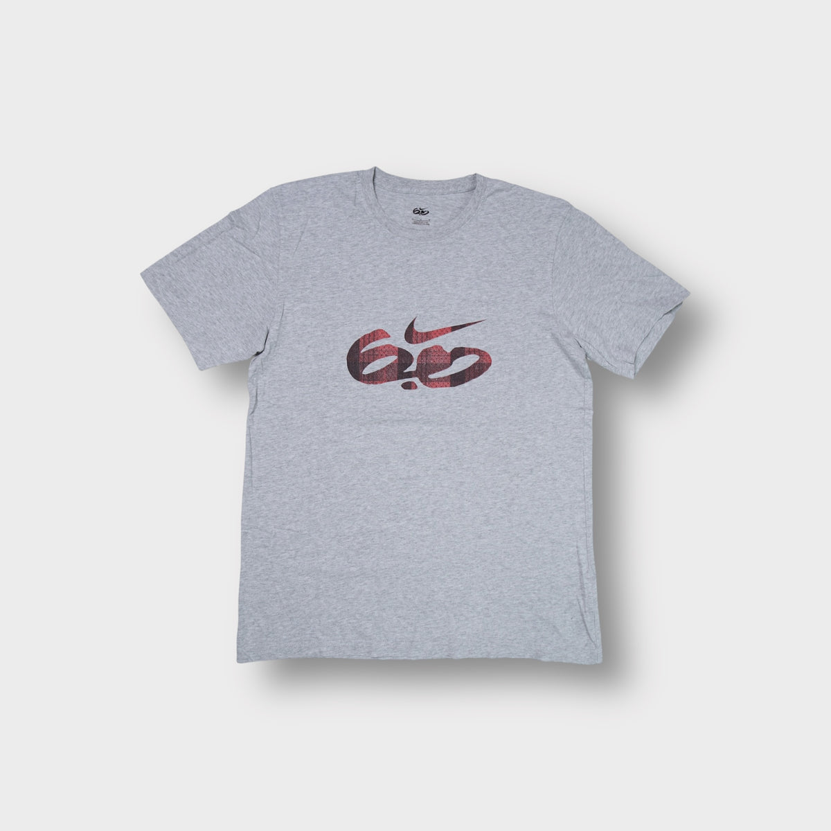 Grey Nike 6.0 T-Shirt featuring a red plaid swoosh logo printed on the chest