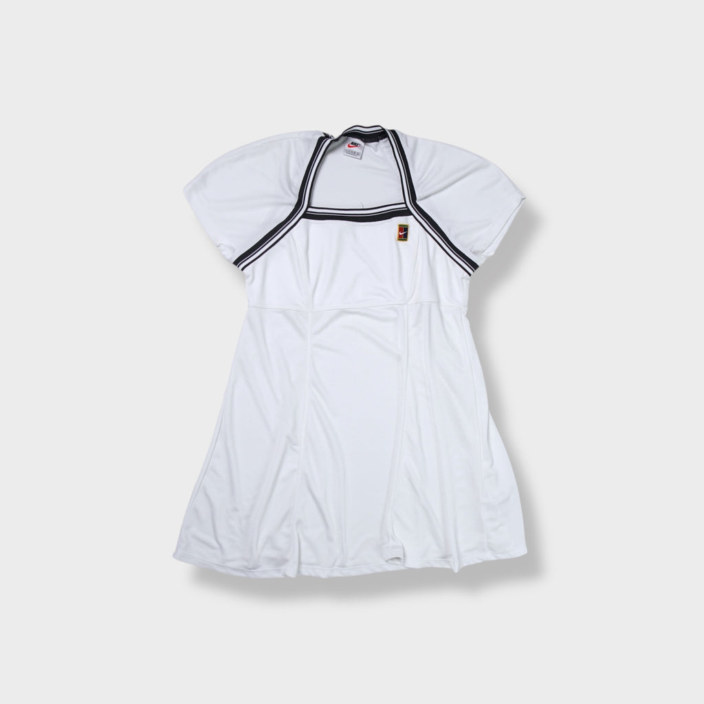 White Nike tennis dress featuring striped trim and an embroidered court logo patch