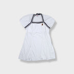 White Nike tennis dress featuring striped trim and an embroidered court logo patch