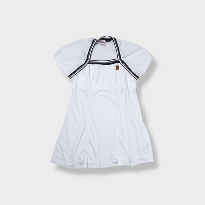 White Nike tennis dress featuring striped trim and an embroidered court logo patch