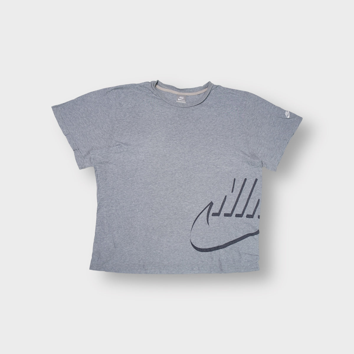 Nike grey T-Shirt with a stylized swoosh graphic on the lower left hem