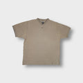 Nike T-Shirt in beige featuring a ribbed V-neck collar and embroidered chest swoosh