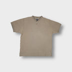 Nike T-Shirt in beige featuring a ribbed V-neck collar and embroidered chest swoosh