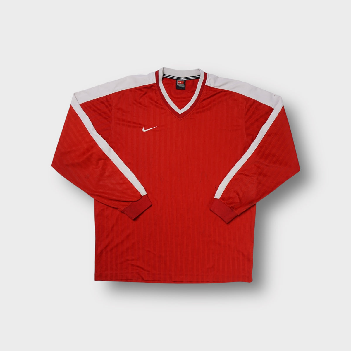Red Nike long-sleeve jersey with white shoulder panels and an embroidered swoosh
