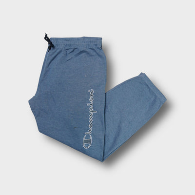 Champion blue sweatpants featuring white outline script printed vertically on left leg
