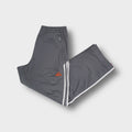 Adidas grey trackpants featuring white side stripes and an embroidered orange logo.