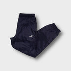 Puma trackpants in navy blue featuring an embroidered white logo on the thigh