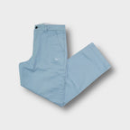 Nike light blue cotton trousers featuring a white Swoosh logo embroidered on the left leg.