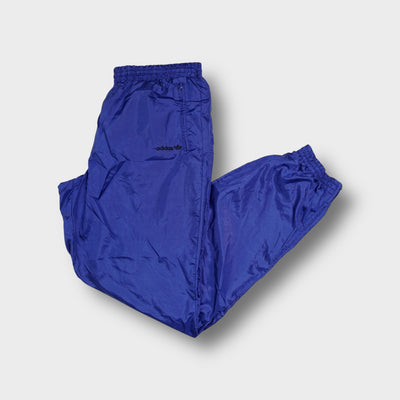 Adidas blue trackpants with small black embroidered Trefoil logo on thigh