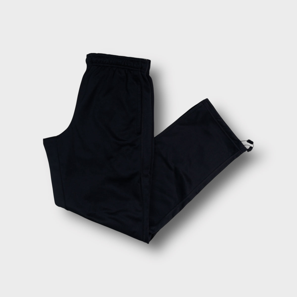 Black Nike trackpants featuring a large grey vertical logo print on the lower leg.