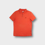 Orange C.P. Company polo shirt with embroidered chest logo patch
