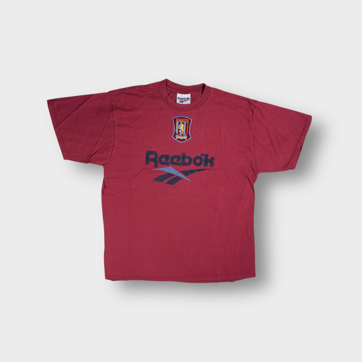 Red Reebok T-Shirt featuring an embroidered Aston Villa F.C. Crest and printed logo