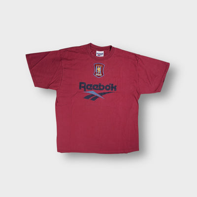 Red Reebok T-Shirt featuring an embroidered Aston Villa F.C. Crest and printed logo