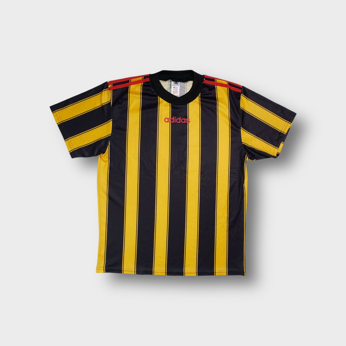 Adidas yellow shirt with vertical stripes and red central chest logo