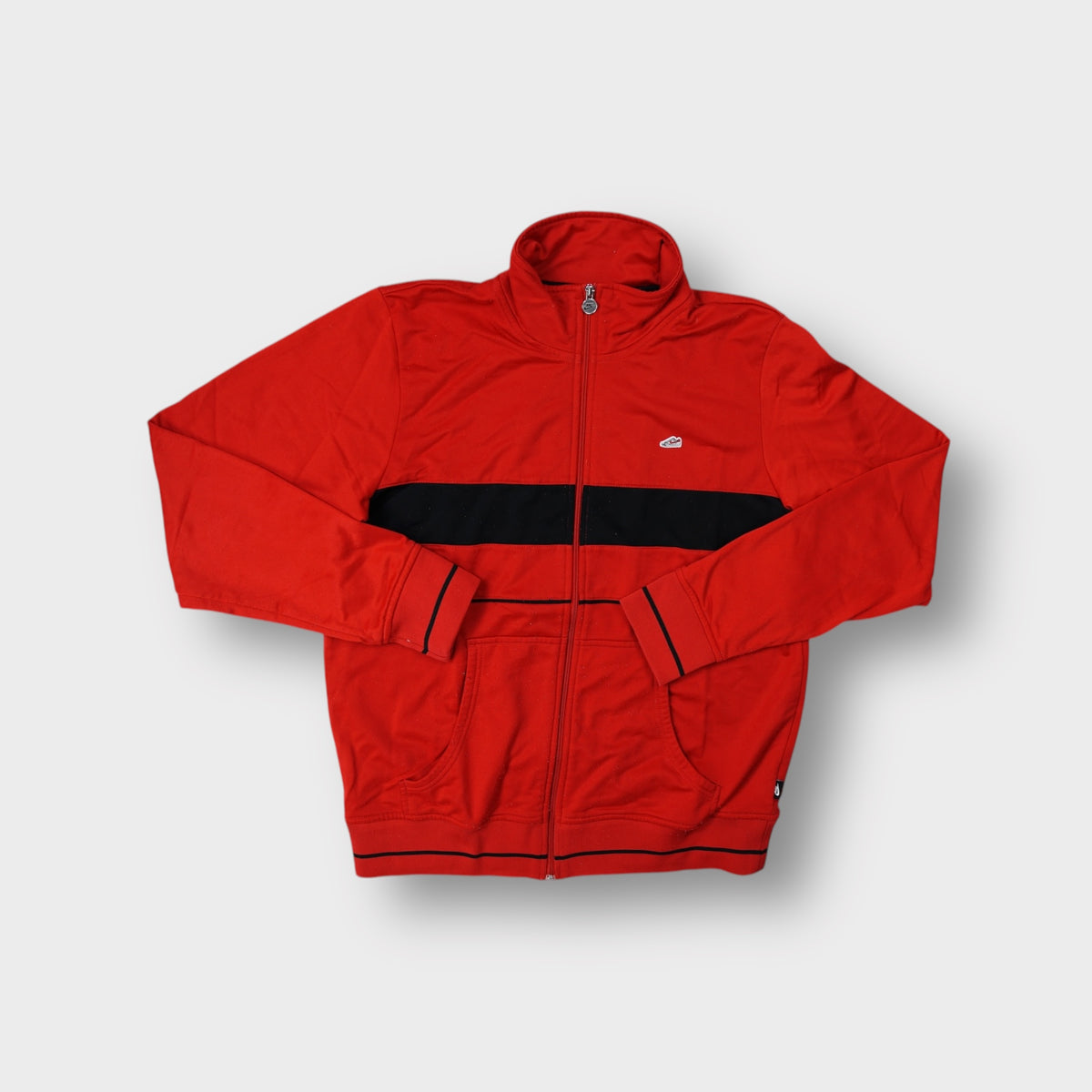 Nike track jacket in red featuring an embroidered sneaker patch and black chest band