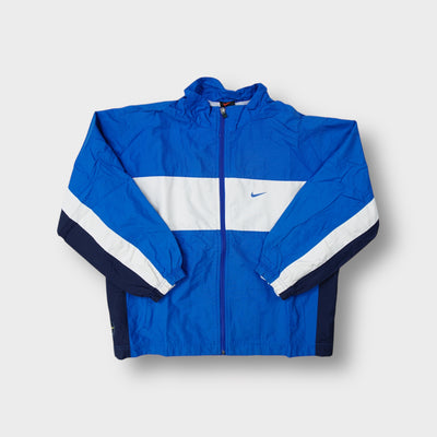 Nike track jacket in blue with a white chest panel and small embroidered swoosh logo.