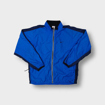 Nike track jacket in blue featuring an embroidered black swoosh on the chest and a full front zip