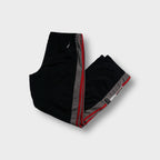 Adidas black trackpants featuring grey and red side stripes with ankle patches
