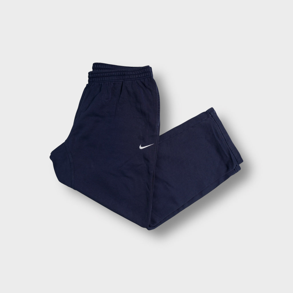 Blue Nike sweatpants featuring a small white embroidered Swoosh logo on the leg