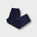 Blue Nike sweatpants featuring a small white embroidered Swoosh logo on the leg