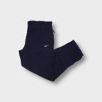 Nike trackpants in dark blue featuring a small white embroidered swoosh on the thigh