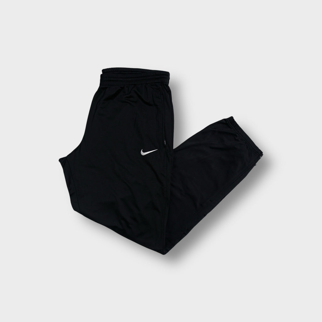 Black Nike trackpants featuring a white embroidered Swoosh logo on the upper leg